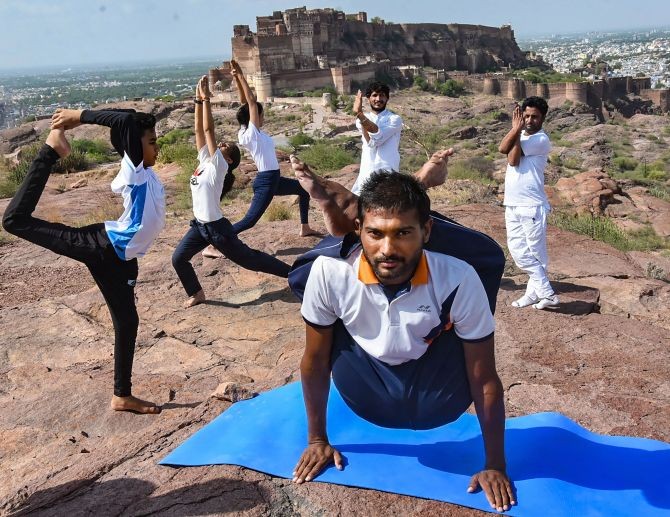 Youngsters perform yoga on the occasion of International Yoga Day, at Mehrangarh Fort in Jodhpur, Sunday, June 21, 2020. (PTI Photo)(